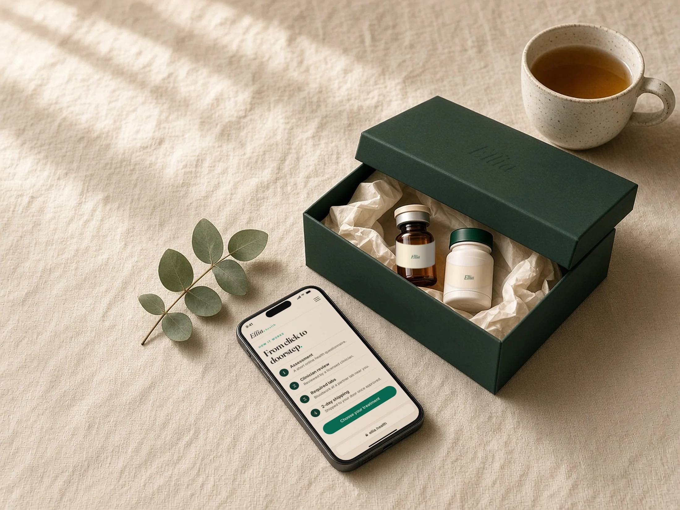 Ellia delivery box with medication vials beside a phone showing the Ellia site